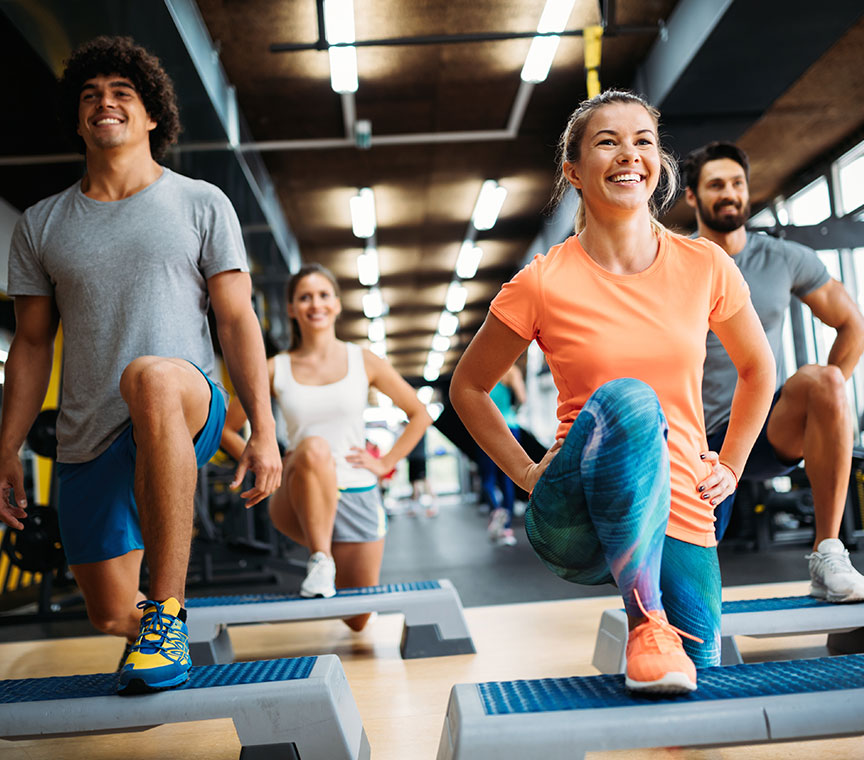 A certified adaptive fitness trainer assisting a client with special needs in a workout session at GymGuyz North Queens.